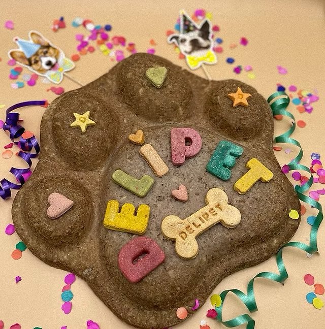Torta natural en forma de huella con letras y galletas que dicen Delipet